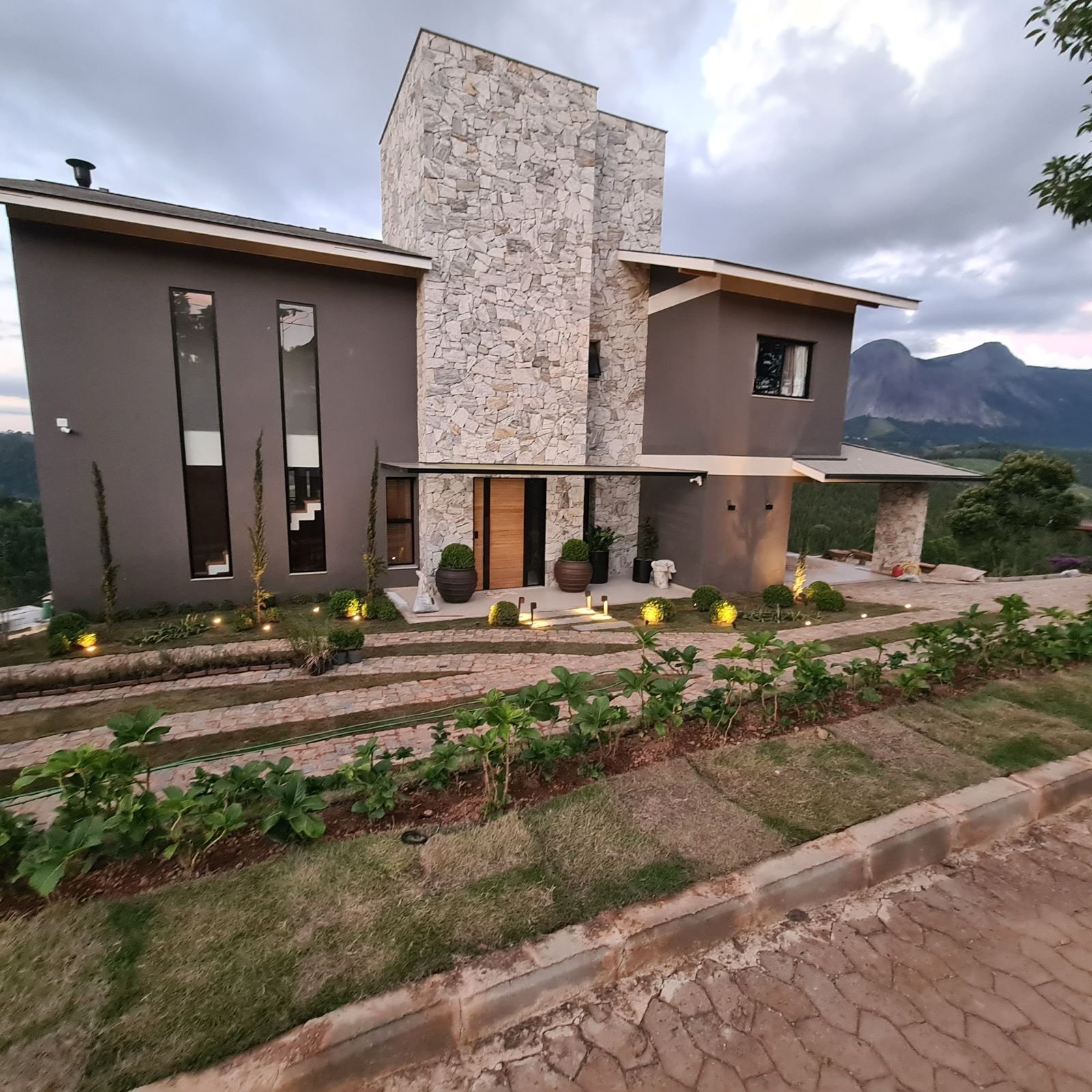 Casa entregue em Aracê, Domingos Martins, com fachada em pedra e paisagismo
