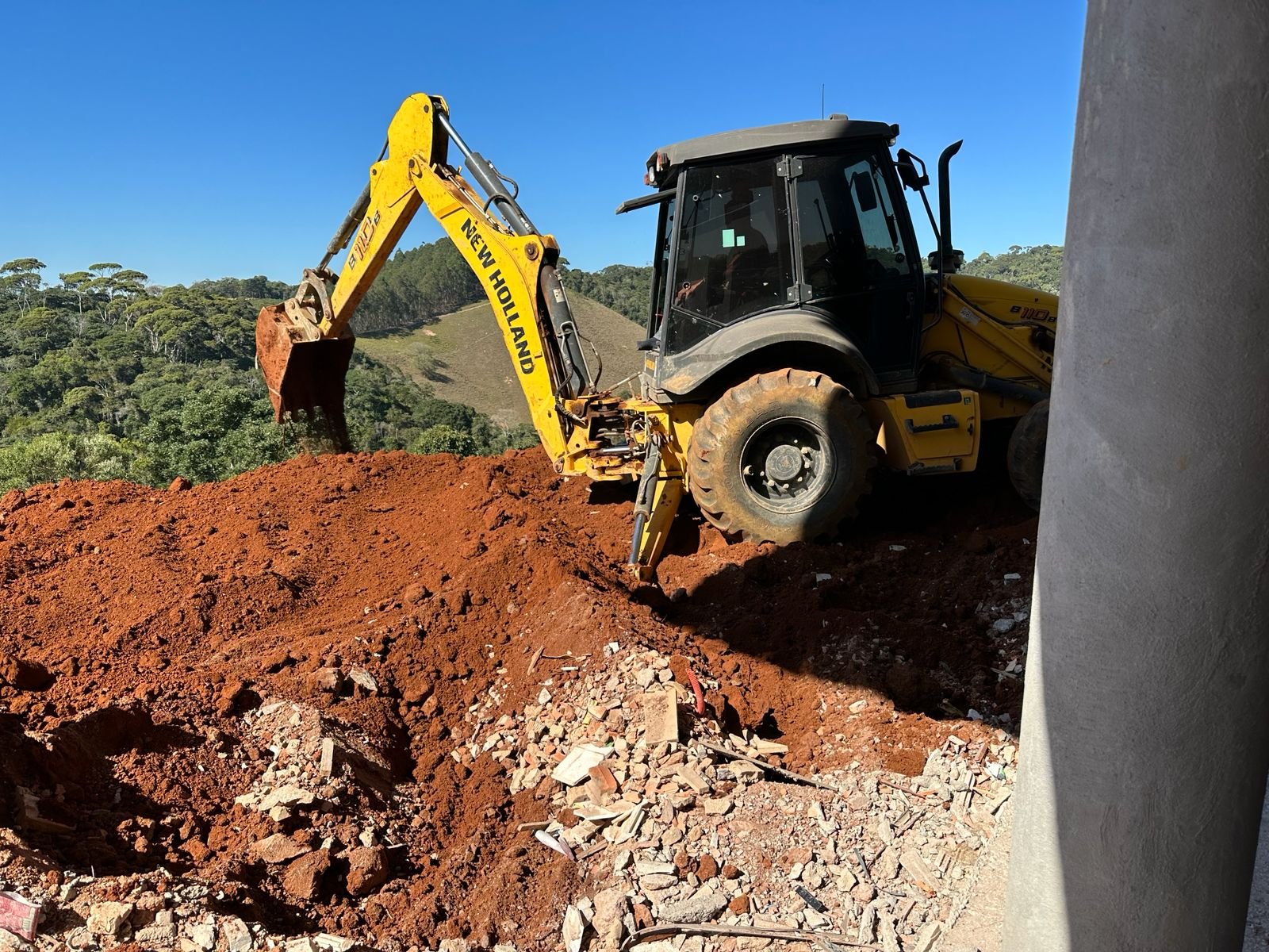 Retroescavadeira movimentando terra no canteiro